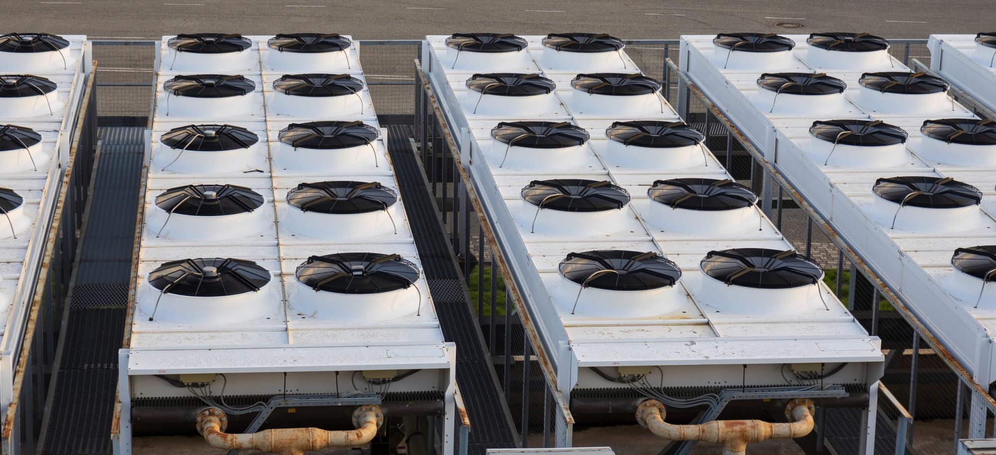 Row of blocks of industrial air conditioning units for large room outdoors. View on rows of block of industrial air conditioning units for buildings and large facilities. Modern HVAC system for commercial building cooling outdoors